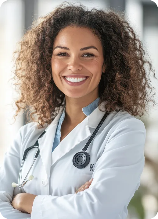 Médica sorrindo de braços cruzados com estetoscópio no pescoço